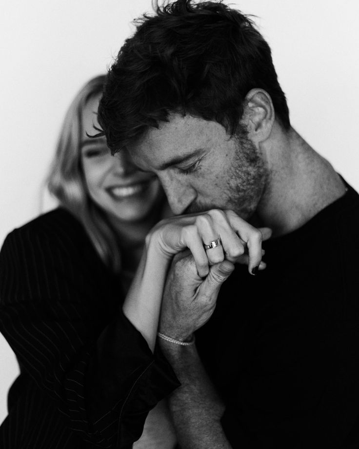 black and white photograph of a man and woman smiling at each other with their hands together