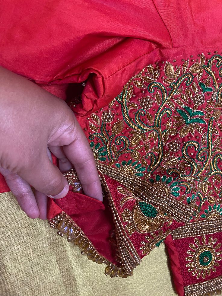 Upgrade your traditional attire with our Maggam|Aari work blouse, featuring exquisite hand embroidery in red and green. The PrincessCut design and padded support ensures a perfect fit for sizes 36"-42". Elevate your saree or lehenga ensemble with this stunning blouse. Dry clean only. Red Art Silk Traditional Wear With Dabka Work, Red Traditional Wear With Dabka Work In Art Silk, Red Dola Silk Traditional Wear With Dabka Work, Traditional Wear With Intricate Embroidery For Puja, Red Chanderi Choli With Dabka Work, Traditional Wear With Intricate Embroidery For Navratri Puja, Raw Silk Choli With Dabka Work For Traditional Ceremonies, Traditional Wear With Intricate Embroidery For Puja And Navratri, Designer Red Blouse Piece With Dori Work