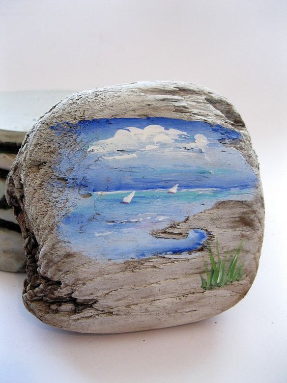 two rocks with paintings on them sitting next to each other