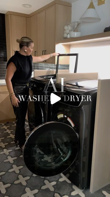 a woman standing next to a washer in a kitchen