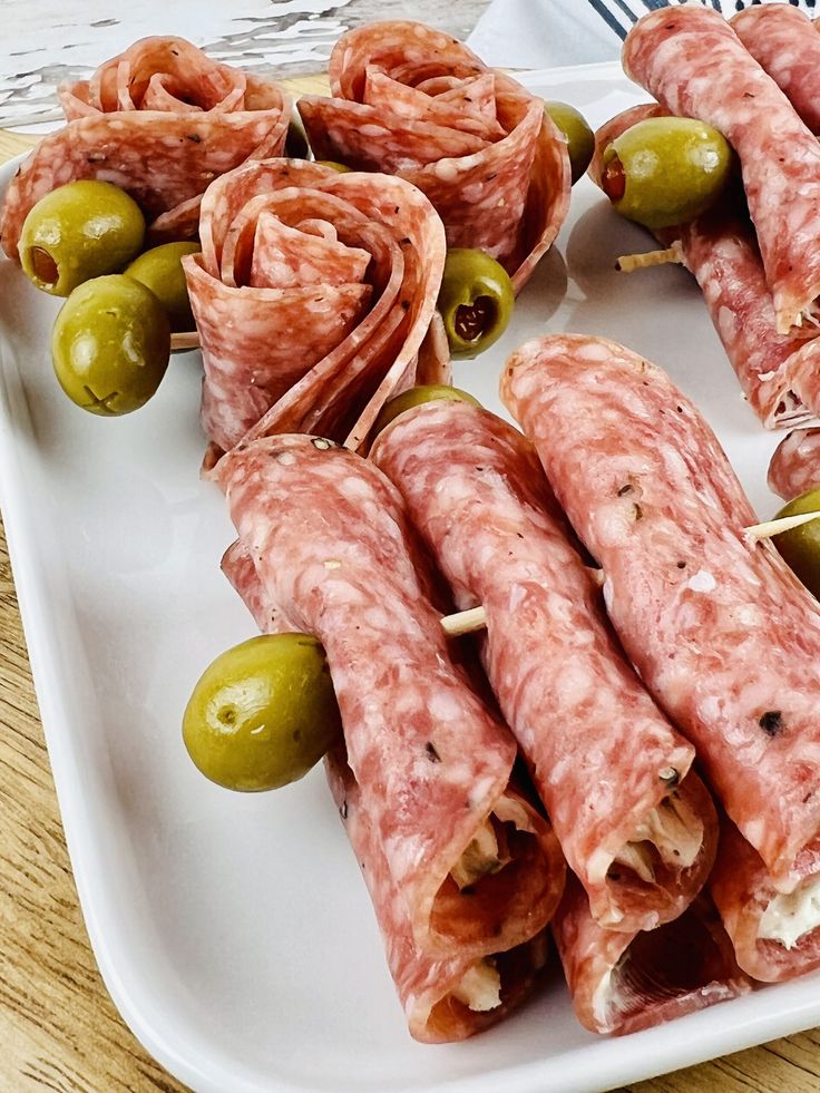 some food is laying out on a white plate with olives and breadsticks