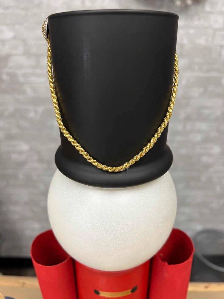 a black top hat sitting on top of two red vases next to each other