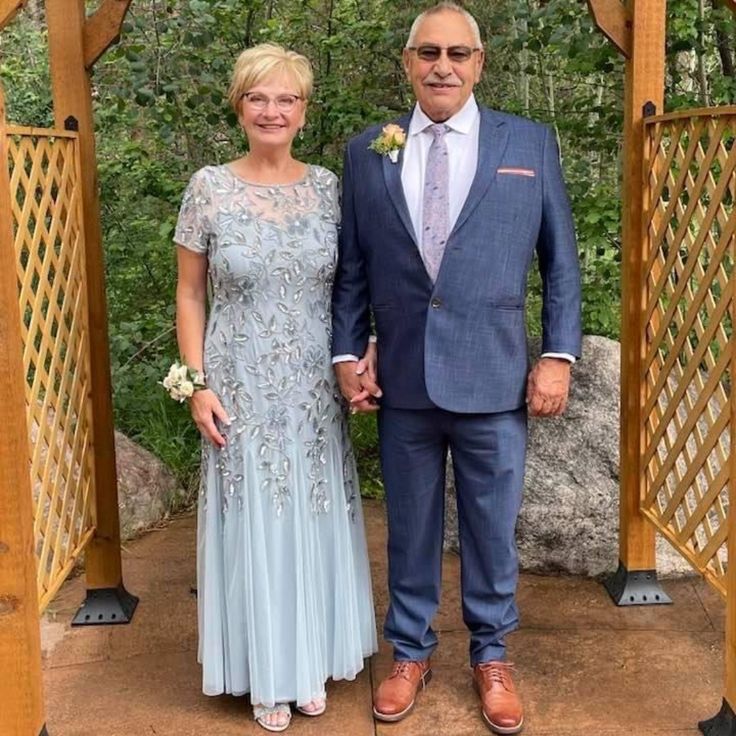 an older man and woman standing in front of a gazebo