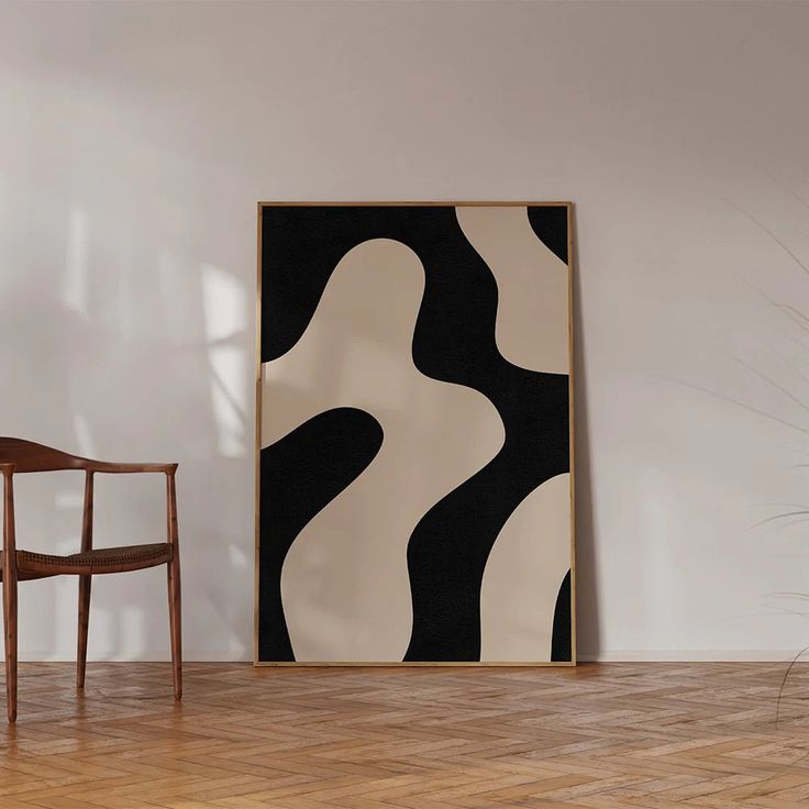 a chair sitting in front of a painting on the wall next to a wooden floor