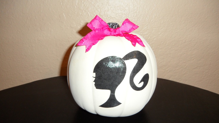 a white pumpkin decorated with a silhouette of a woman's head and pink bow