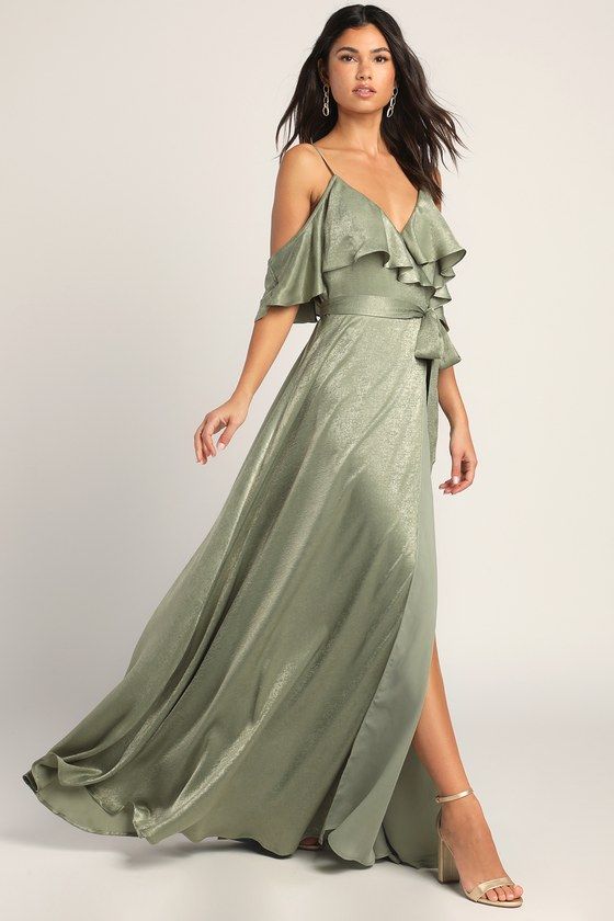 a woman wearing a green dress with one shoulder and ruffles on the side