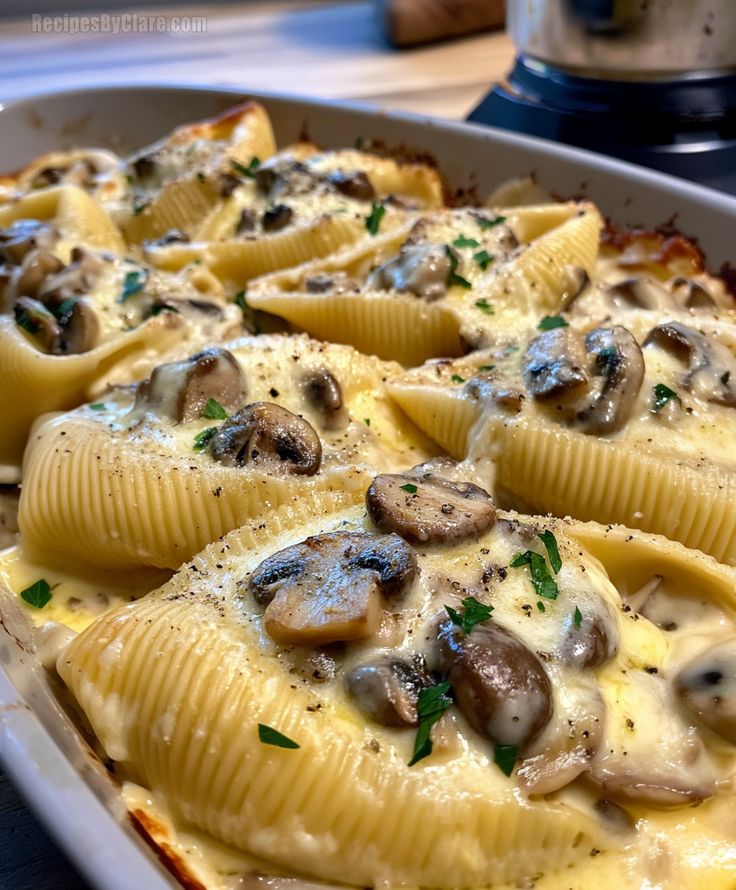 a casserole dish with shells and mushrooms on it, ready to be eaten