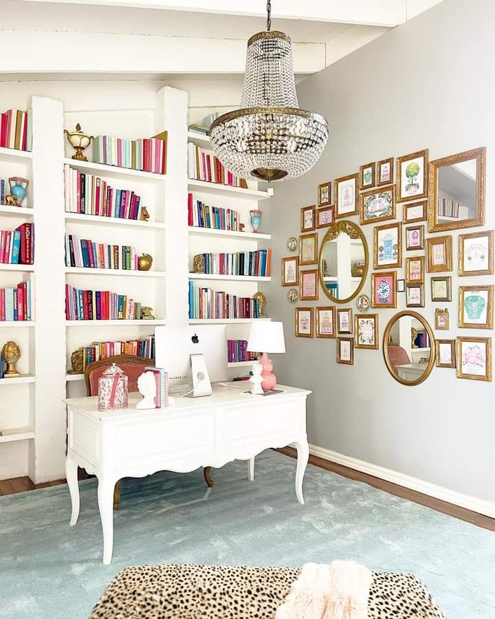 a living room filled with lots of furniture and bookshelves next to a white table