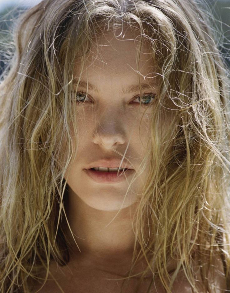 a woman with long blonde hair and blue eyes is staring at the camera while she's covered in frizz