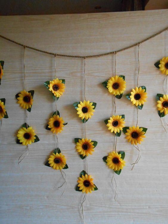 sunflowers are hanging on a string with leaves and flowers attached to the strings