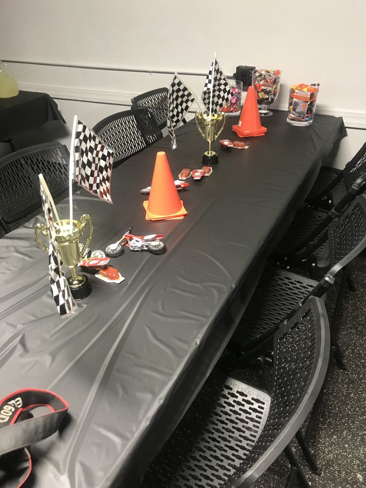 a long table covered with black cloth and orange cone hats on top of it's bases