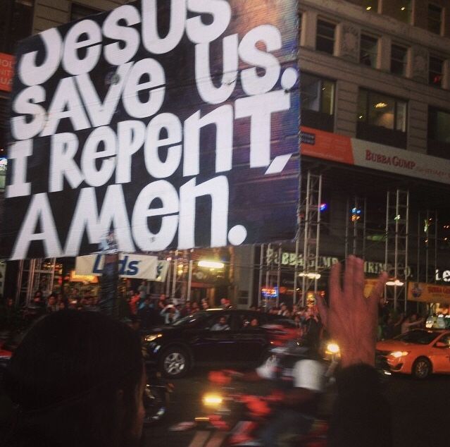 a group of people standing in front of a large sign that says jesus save us, i repent amen