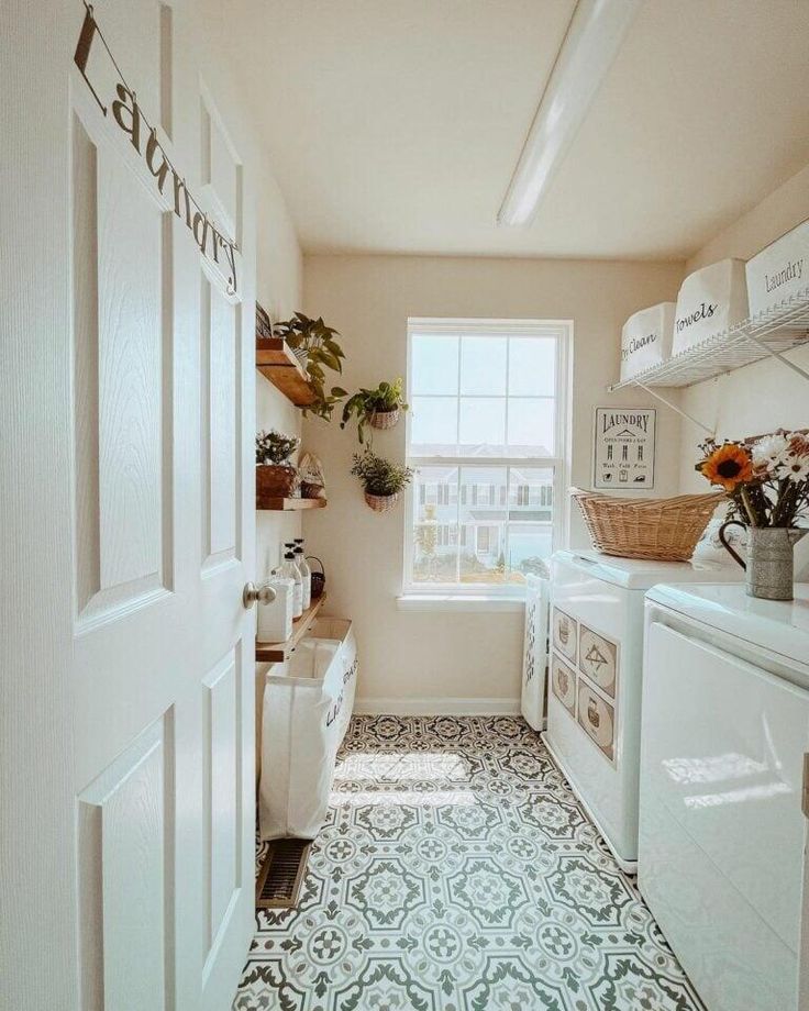 a kitchen with white appliances and lots of plants in the window sill above the washer and dryer