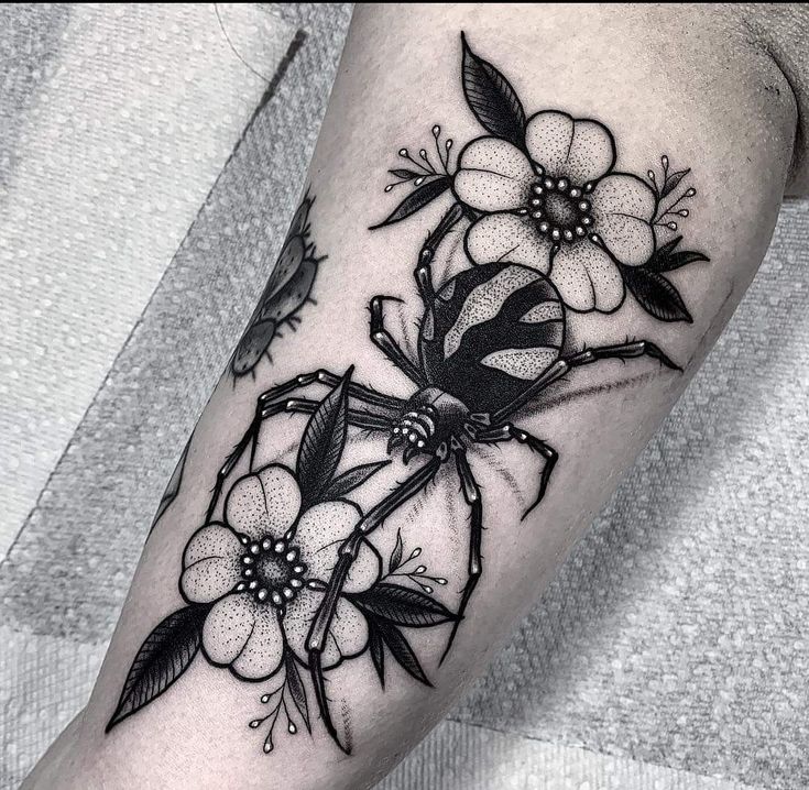 a black and white flower tattoo on the arm