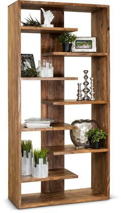 an open bookcase with plants and books on it's shelves, against a white background