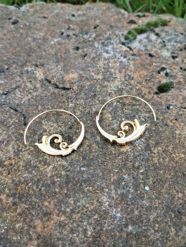 A pair of geometric earrings made of metal alloy. Unique Small Hoop Metal Earrings, Gold Spiral Earrings For Pierced Ears, Spiral Metal Wrap Earrings, Metal Spiral Wrap Single Earring, Swirl Earrings For Pierced Ears, Modern Jewelry With Unique Spiral Design, Metal Spiral Wrap Earrings, Swirl Shaped Metal Earrings As Gift, Gold Swirl Earrings For Pierced Ears