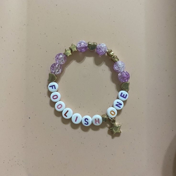 a beaded bracelet with the word mom written on it and two little stars attached