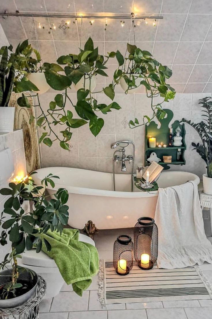 a bathroom with plants and candles in the bathtub, along with other decor items