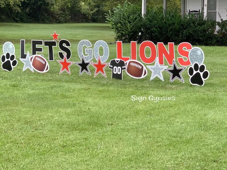 a yard sign that says let's go lions with footballs and paw prints