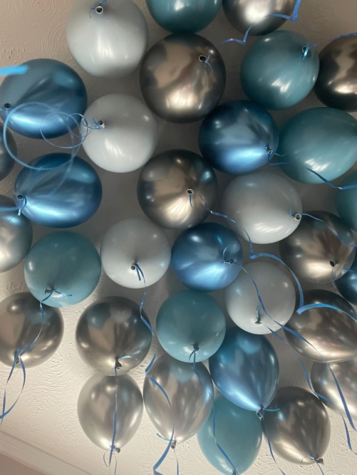 blue and silver balloons are arranged in the shape of a ballon, on a ceiling