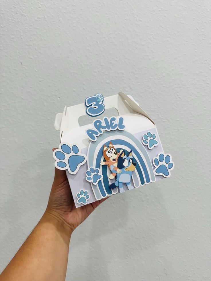 someone holding up a box with paw prints on it