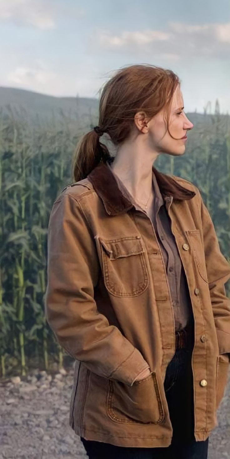 a woman standing in front of a corn field