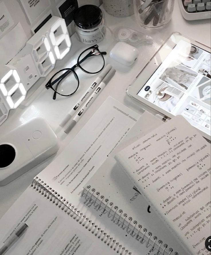 an alarm clock sitting on top of a desk next to some papers and other items