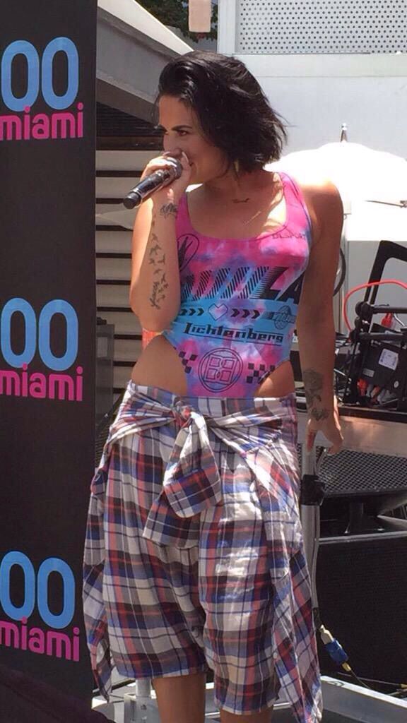 a woman in plaid shorts is singing into a microphone