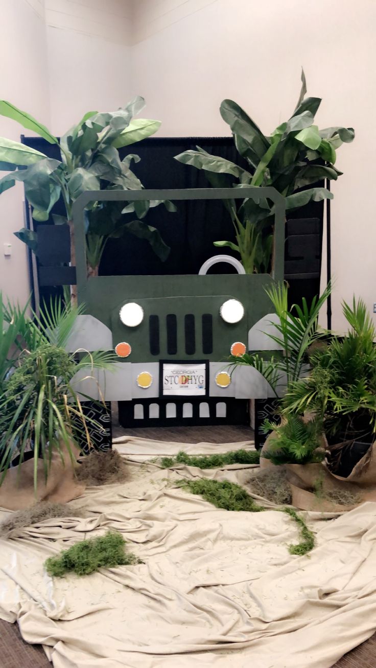 a green vehicle with plants in it on top of a white cloth covered tablecloth