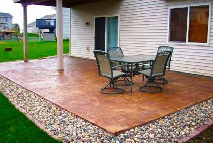 a patio covered in gravel with chairs and table