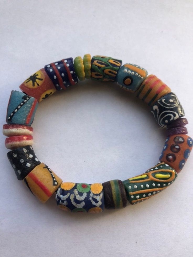 "This colorful bracelet is handmade from recycled glass, formed into beads known as Krobo beads, hand painted, and fired in a kiln in Ghana, West Africa.  The bracelet is 6\" and is strung on 2mm white elastic cord. It features hand-painted African designed glass beads. Other sizes may be ordered as well as earrings and other jewelry. Just contact us.  All proceeds from the sale of this jewelry go to our non-profit organization Mawuvio's Outreach Programme, which is providing free education and care for orphaned and disadvantaged children in Ghana. The money is used to support a 6 classroom and 2 dormitory school that provides over 200 children with the tool they need to succeed - Education. Students & staff at Mawuvio's Outreach Programme string the beads themselves to create handmade bra Multicolor Hand Painted Round Bead Jewelry, Traditional Multicolor Stretch Bracelet With Large Beads, Artisan Multicolor Beaded Stretch Bracelet, Traditional Multicolor Stretch Bracelet With Wooden Beads, Artisan Multicolor Wooden Beaded Bracelets, Handmade Multicolor Recycled Glass Beads, Artisan Hand-strung Stretch Bracelet For Festivals, Artisan Wooden Beads Stretch Bracelet, Unique Hand Painted Multicolor Bracelets