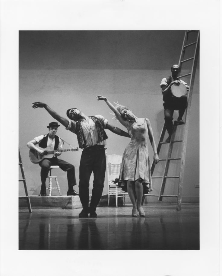 an old black and white photo of three people on a stage with their arms in the air