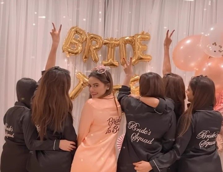 the girls are standing in front of some balloons