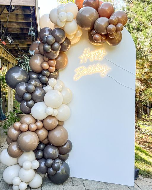 a bunch of balloons that are on top of a sign