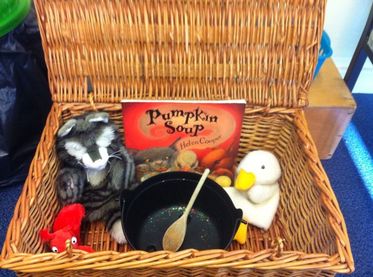 a basket filled with toys and books on top of a blue carpeted floor next to a stuffed animal