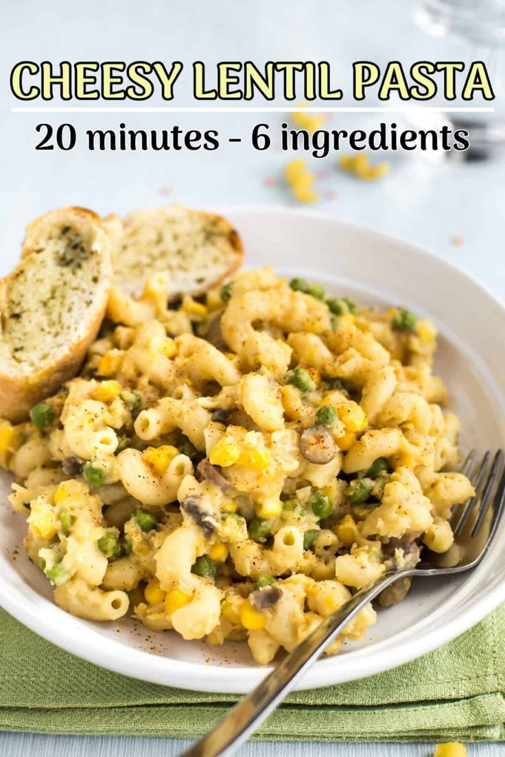 a white plate topped with macaroni and cheese next to two slices of bread