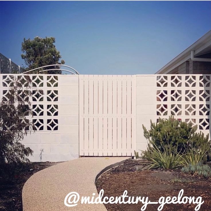 an image of a white fence that is in the middle of a yard with plants