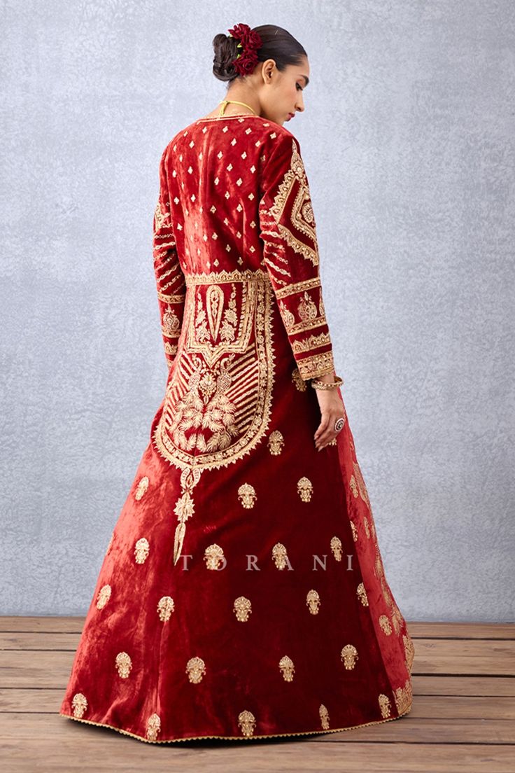 Red long jacket with contrast hand embroidered floral motifs all-over and loop button closure in front. Comes with sleeveless yoke embroidered anarkali.
Component: 2
Pattern: Embroidery
Type Of Work: Dori and Adda Work
Neckline: Leaf
Sleeve Type: Anarkali: Sleeveless and Jacket: Full
Fabric: Slub Silk
Color: Red
Other Details: 
Anarkali trim on the border
Floral and peacock embroidered motifs
Gota patti trim on the neckline and sleeves
Low back with tie up and tassels
Occasion: Destination Weddi Anarkali Sleeveless, Leaf Sleeve, Embroidered Anarkali, Embroidered Motifs, Types Of Work, Pattern Embroidery, Sleeveless Jacket, Silk Embroidery, Long Jacket