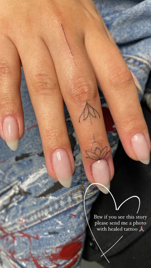 a woman's hand with a small tattoo on it