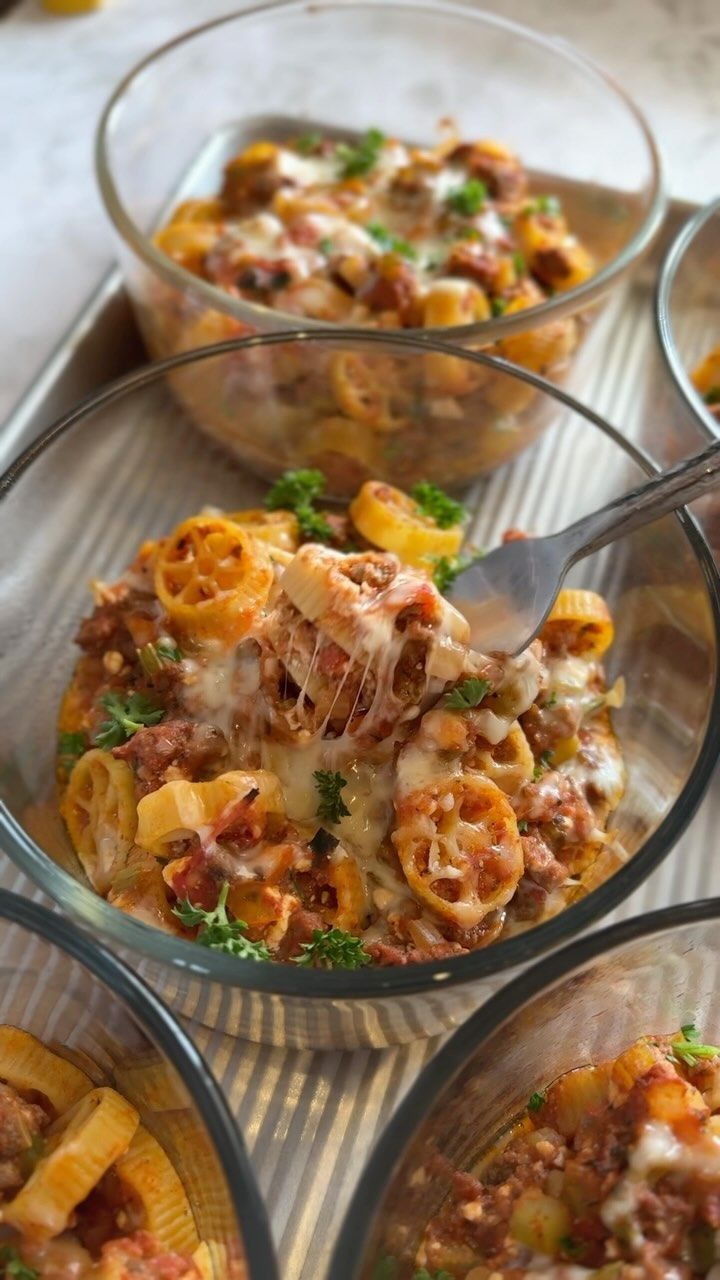 four glass bowls filled with pasta and sauce