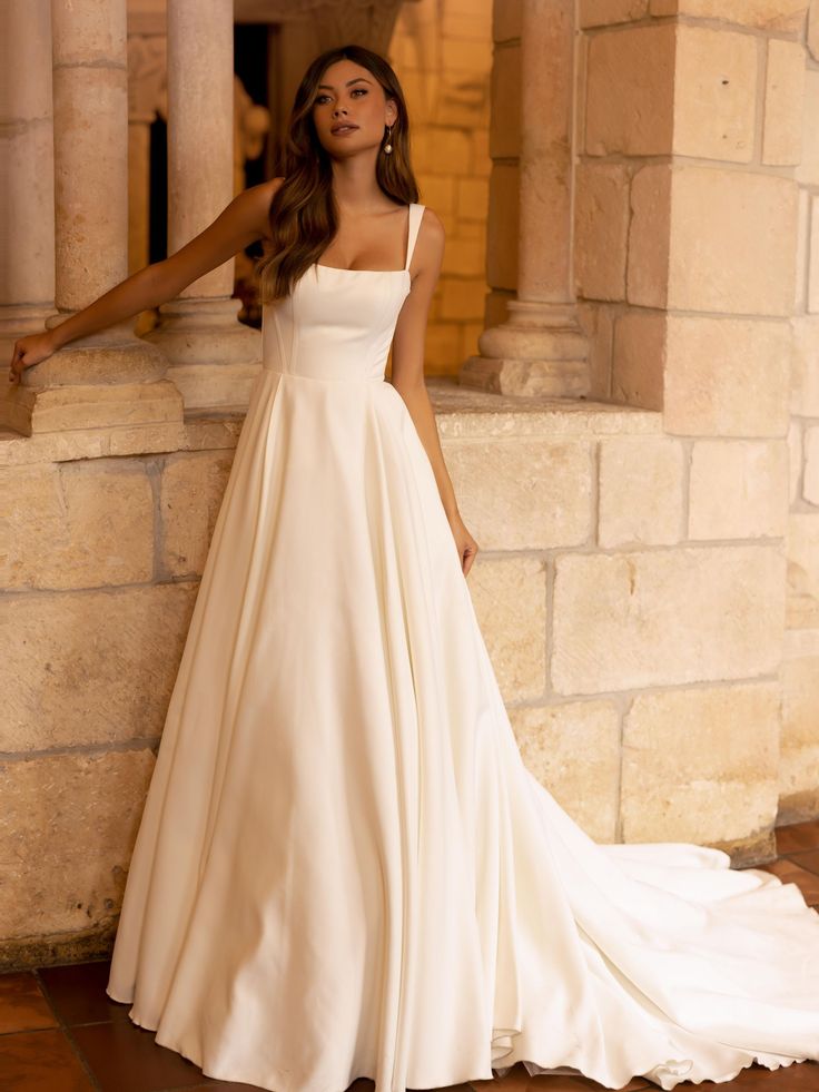 a woman in a wedding dress leaning against a wall