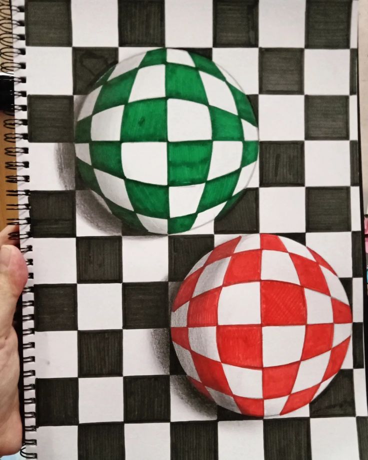 someone is drawing two balls on a checkered board