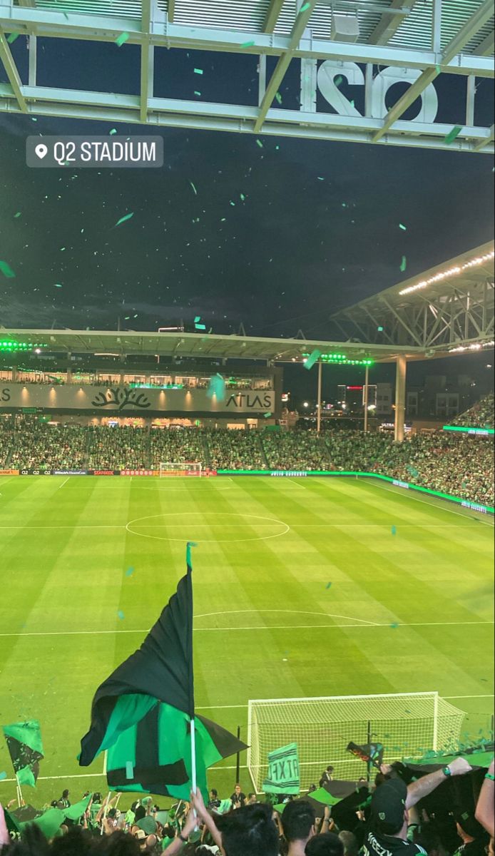 a stadium filled with lots of people holding flags and confetti in the air