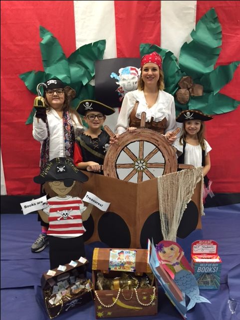 a group of people dressed up in pirate costumes standing behind a wooden ship and steering wheel