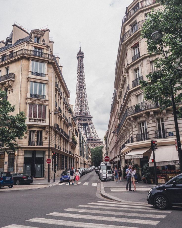 the eiffel tower towering over the city of paris is seen from across the street