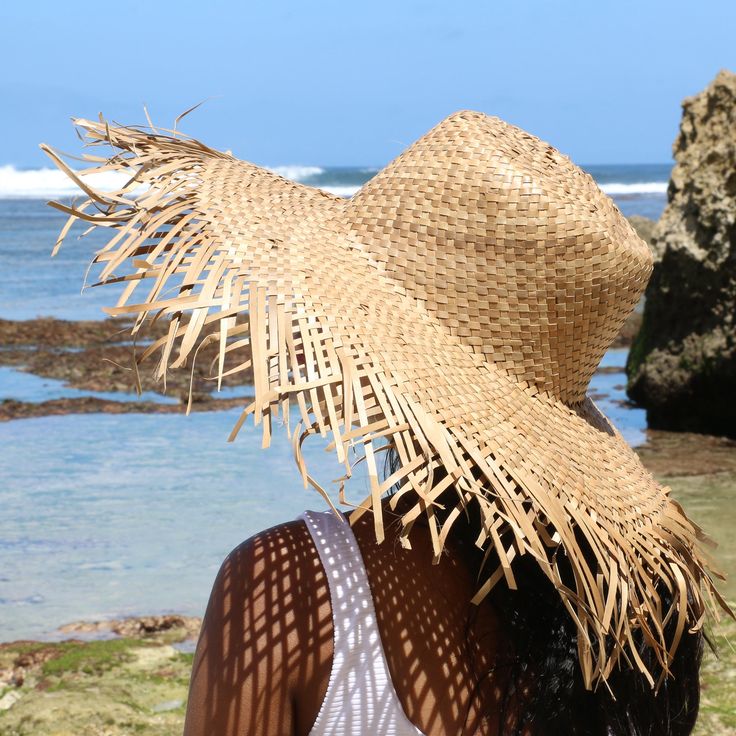 Our wide brimmed with frayed edge hat is the perfect stylish and functional accessory for Summer, poolside party, walk in the park or a day at the beach with friends! Featuring a 4.5" brim and classic round crown. Lightweight and easy to make makes this style a great travel accessory. Our hat collection is sustainably handcrafted by local artisans in Indonesia using eco-friendly natural materials to craft each piece. Each handmade piece is uniquely handmade for you and may vary slightly in color Summer Festival Wide Brim Panama Hat, Wide Brim Sun Hat With Fringe, Brimmed Straw Hat For Pool Vacation, Brimmed Straw Hat For Pool And Vacation, Beachwear Brimmed Hat For Vacation, Summer Panama Hat For Pool In Natural Color, Brimmed Hats For Pool Vacation, Wide Brim Panama Hat For Beach Festival, Wide Brim Panama Hat For Beach Season Festivals