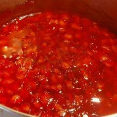 a pot filled with red sauce sitting on top of a stove