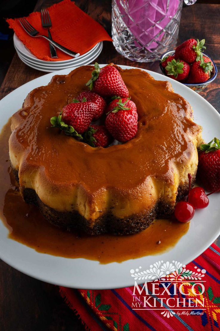 a cake with chocolate frosting and strawberries on top sits on a white plate