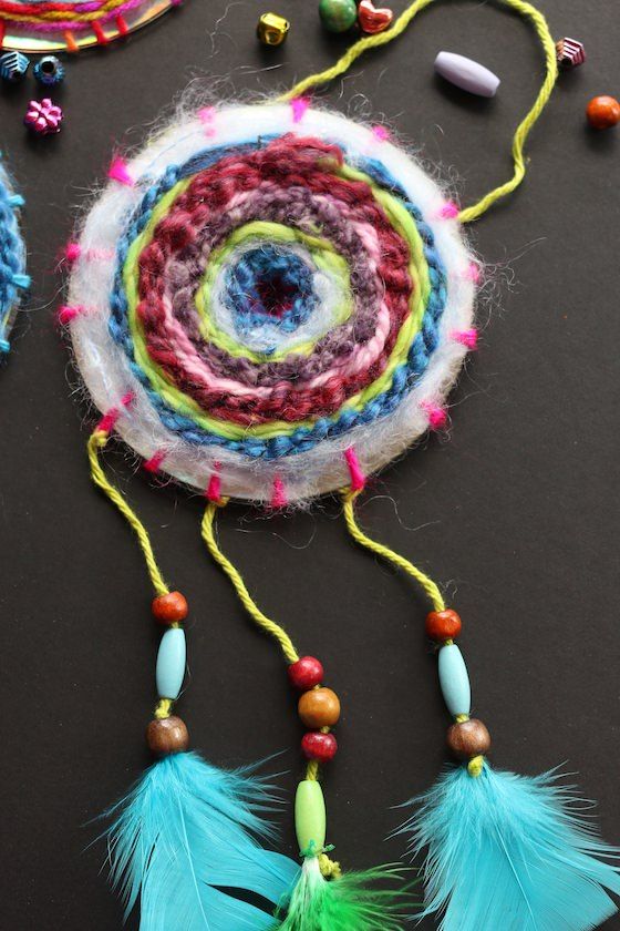 a colorful piece of art with beads and feathers