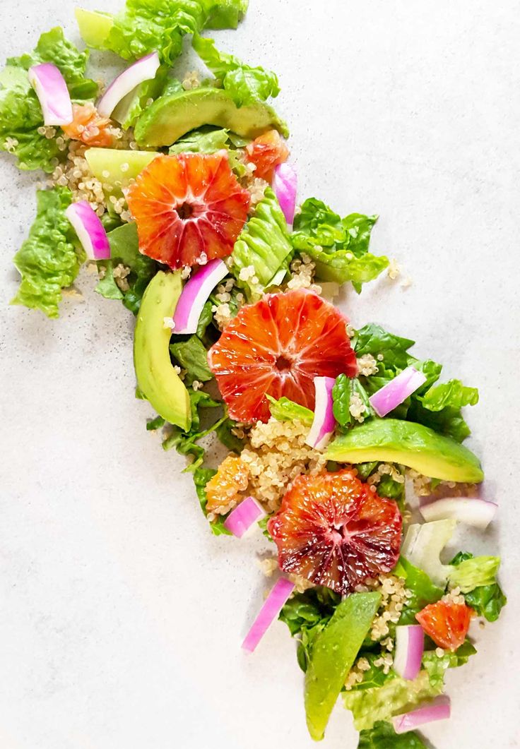 an orange and avocado salad with shaved quinoa on top is shown